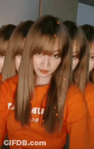 Women In Orange Shirts Looking At Camera GIF