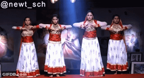 Women Performing In Front Of Newt Sch Sign GIF