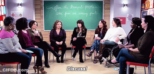 Women Sitting In Circle In Front Of Chalkboard Saying Discuss GIF