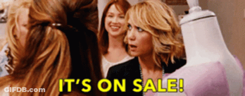 Women Standing Around Mannequin Saying It's On Sale GIF