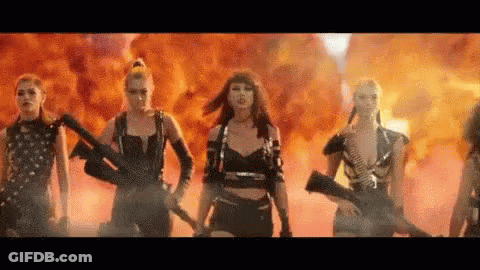 Women Standing In Front Of Fire Holding Guns GIF