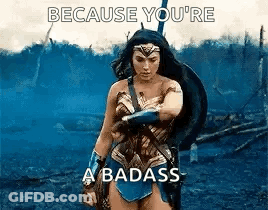 Wonder Woman Is Standing In The Middle Of A Field With A Shield And A Sword . GIF
