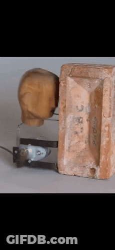 Wooden Head Next To Brick Number 3 GIF