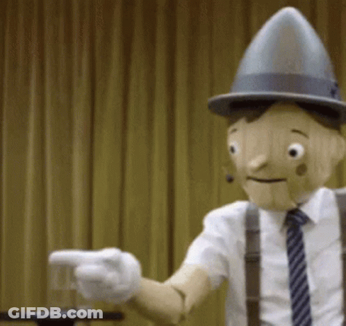 Wooden Puppet In Hat And Suspenders Pointing GIF