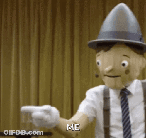 Wooden Puppet In Hat And Tie Pointing Saying Me GIF