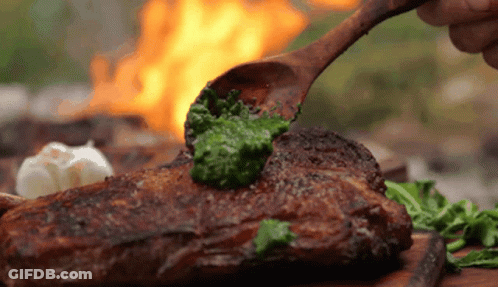 Wooden Spoon Spreading Pesto On Steak GIF