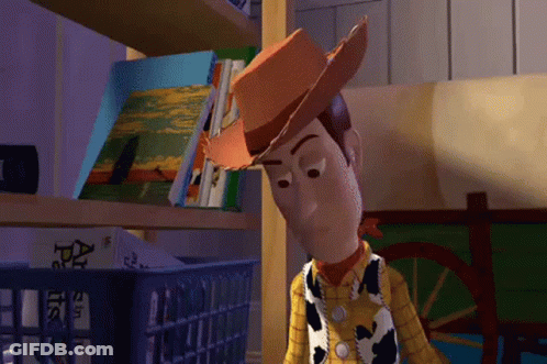 Woody From Toy Story Stands In Front Of A Shelf With Books On It GIF