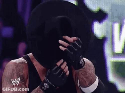 Wrestler Covering Face With Black Hat And Gloves GIF