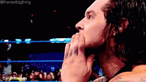 Wrestler Covering Mouth In Ring With Crowd GIF