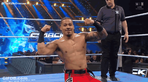 Wrestler Flexing Muscles In Ring With Referee GIF