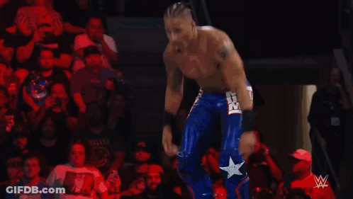 Wrestler Flexing Muscles In Ring With Referee GIF
