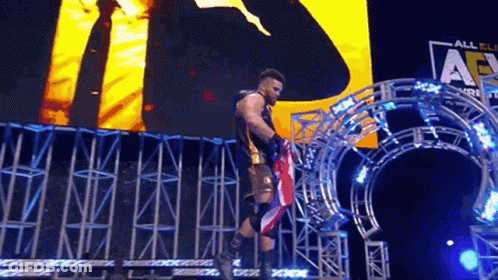 Wrestler Holding American Flag Stage Before Large Screen GIF