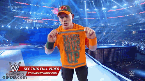 Wrestler Holding Shirt Saying Never Give Up GIF