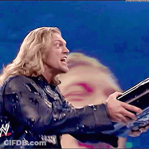 Wrestler Holding Trophy In Front Of Blurry Woman Face GIF