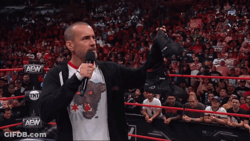 Wrestler In AEW Shirt Holding Shoes GIF