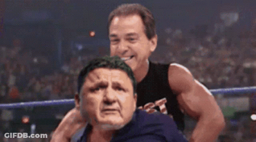 Wrestler In Black Tank Top Holding Opponent's Head GIF