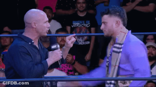 Wrestler In Buck's Of Jericho Shirt Talking To Another Wrestler GIF