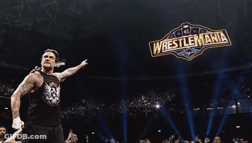 Wrestler In Front Of Wrestlemania Sign GIF