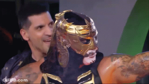 Wrestler In Gold Mask Held By Man GIF