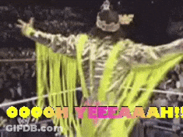 Wrestler In Neon Yellow Outfit Standing In Ring GIF