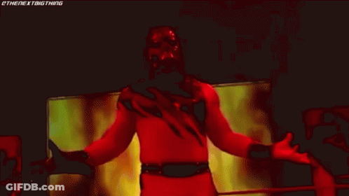 Wrestler In Red And Black Costume On Stage GIF
