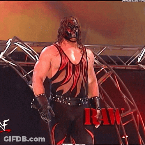 Wrestler In Red And Black In Front Of Stage GIF
