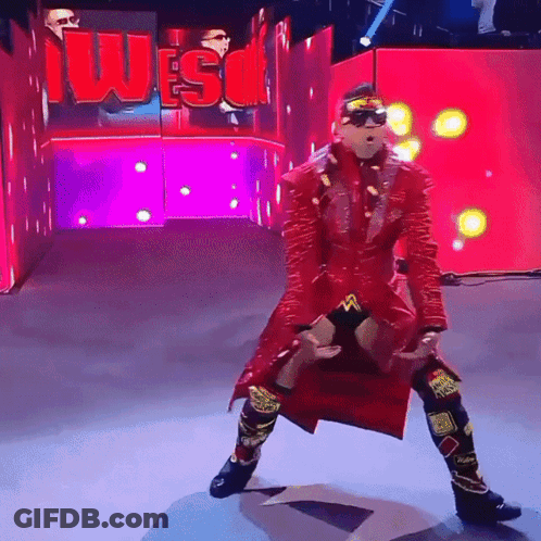 Wrestler In Red Coat Standing In Front Of Wes Sign GIF