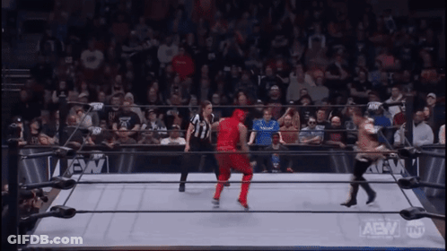 Wrestler In Red Outfit In Wrestling Ring With Crowd GIF