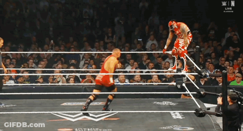 Wrestler In Red Outfit Jumping Over Ropes GIF
