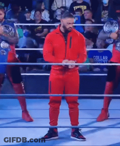 Wrestler In Red Suit Standing In Ring GIF