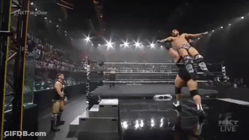 Wrestler Jumping In Ring While Another Stands GIF