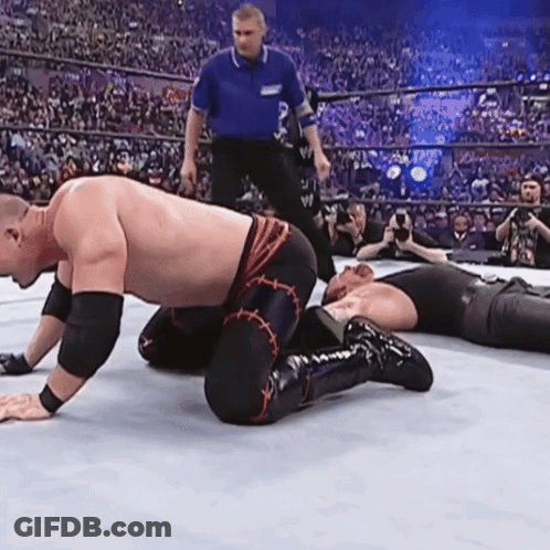 Wrestler Kneeling In Ring While Another Wrestler Lays On Ground GIF