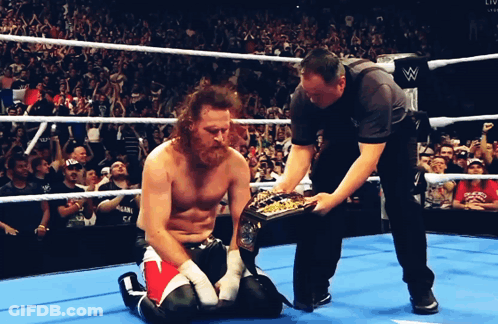 Wrestler Kneeling In Ring With Referee GIF
