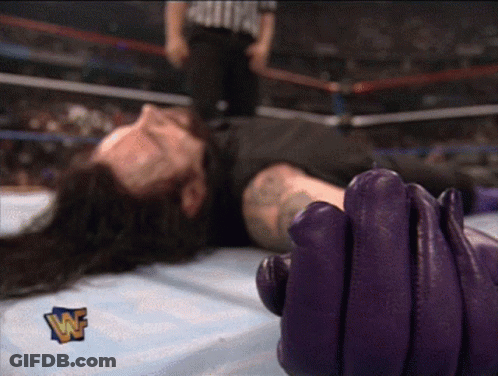 Wrestler Laying On Ground With Purple Glove And W Logo GIF