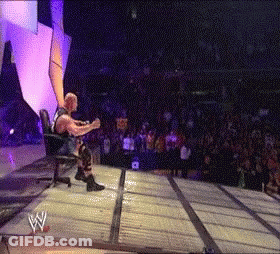 Wrestler Sitting In Chair On Stage With Crowd GIF