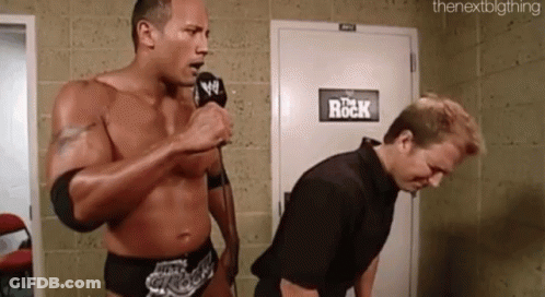 Wrestler Speaking Into Mic Next To Another Wrestler GIF