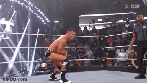 Wrestler Squatting In Ring With CW Logo GIF