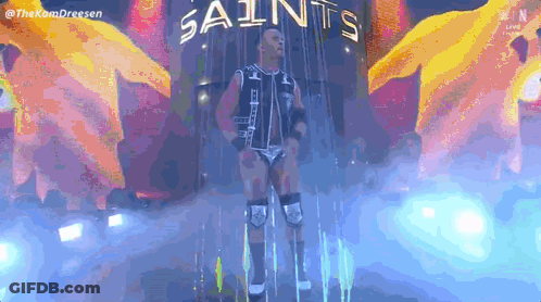 Wrestler Standing In Front Of Saints Sign GIF