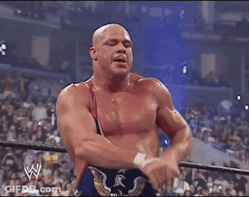 Wrestler Standing Next To Wrestler Lying On Ground GIF