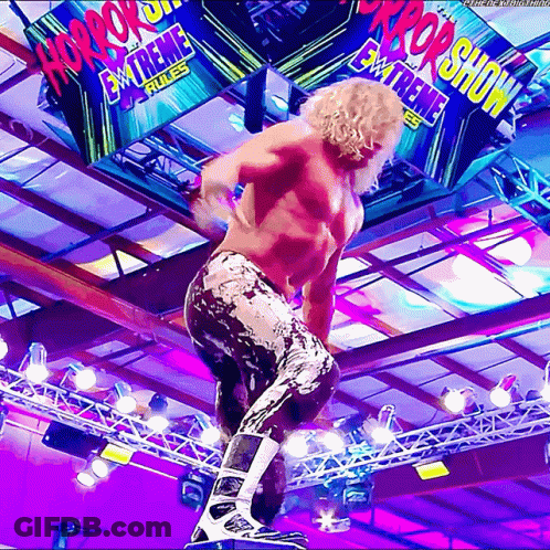 Wrestler Standing On Rope In Front Of Horror Show Sign GIF