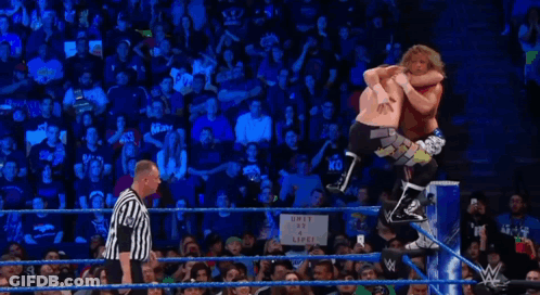Wrestler Upside Down In Ring While Referee Looks On GIF