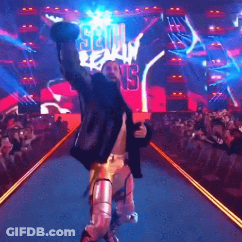 Wrestler Walking Down Ramp Arms Up Seth Reigns Sign GIF