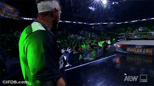 Wrestler Walking On Stage In Green And Blue Jersey GIF