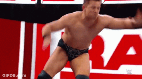 Wrestler Without Shirt In Front Of Red And White Sign GIF