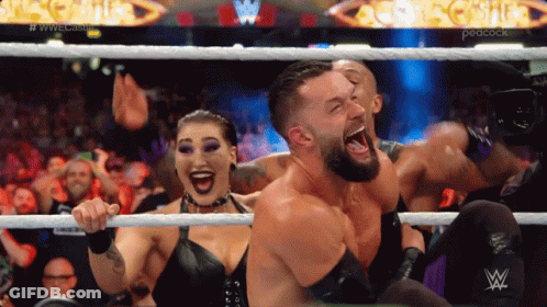 Wrestlers In A Ring With A Peacock Logo In The Background GIF