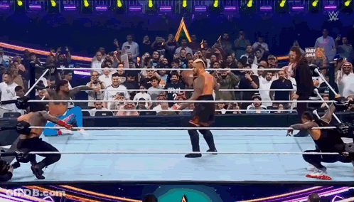 Wrestlers In Ring With Crowd And Mart Gold Sign GIF
