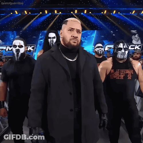 Wrestlers Standing In Front Of Bestofguerrillas Sign GIF