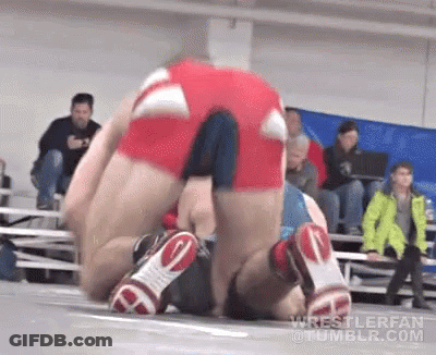 Wrestlers Wrestling On Mat With Crowd Watching GIF