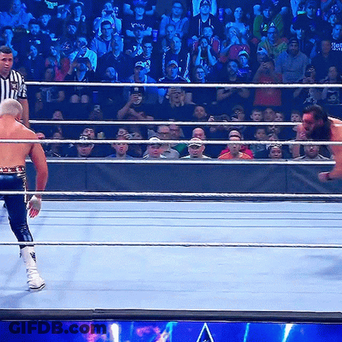 Wrestling Ring With Referee And Wrestler Holding Smackdown Belt GIF