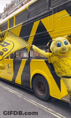 Yellow And Black Double Decker Bus With Mascot GIF